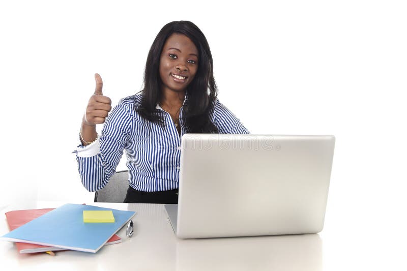 Mujer afroamericana negra de la pertenencia étnica que trabaja en el ordenador portátil del ordenador en la sonrisa del escritori