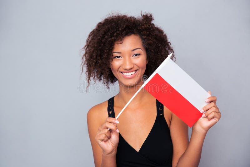 Mujer afroamericana que sostiene la bandera de Polonia imágenes de archivo libres de regalías Mujer afroamericana que sostiene la bandera de Polonia imágenes de archivo libres de regalías
