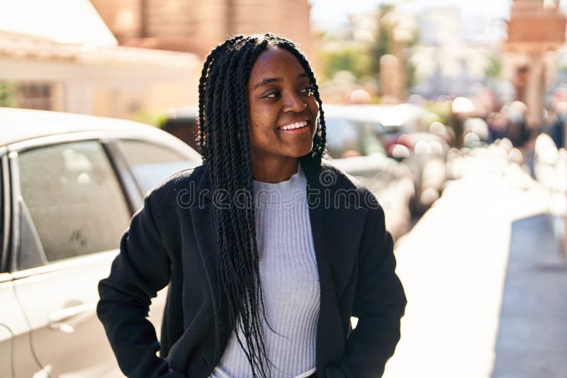 Mujer afroamericana sonriendo confiada mirando al costado de la calle imagen de archivo