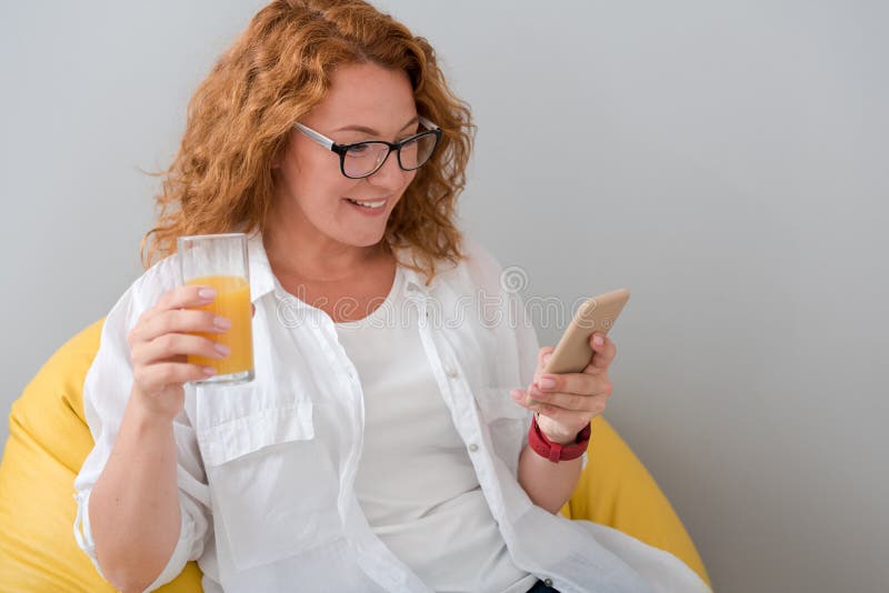 Mujer alegre que usa el teléfono celular imagenes de archivo Mujer alegre que usa el teléfono celular imagenes de archivo