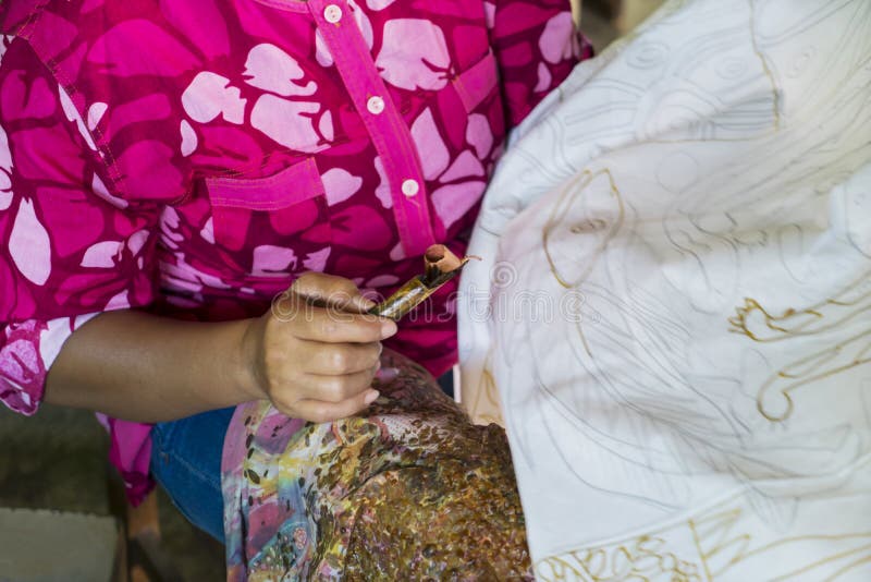 Mujer anónima que hace el batik en una tela imágenes de archivo libres de regalías Mujer anónima que hace el batik en una tela imágenes de archivo libres de regalías
