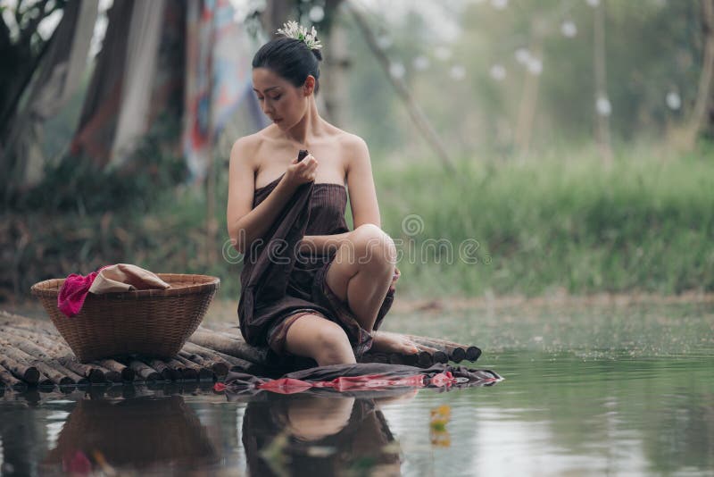 Facilitar aborto Síntomas Mujer Asiática Bañándose En Salong Sentada En Un Puente De Madera Lavando  Ropa En El Río Imagen de archivo - Imagen de persona, rural: 271755773