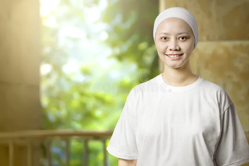 Mujer asiática con una camisa blanca con una sonrisa en la cara de pie en el interior fotos de archivo libres de regalías Mujer asiática con una camisa blanca con una sonrisa en la cara de pie en el interior fotos de archivo libres de regalías