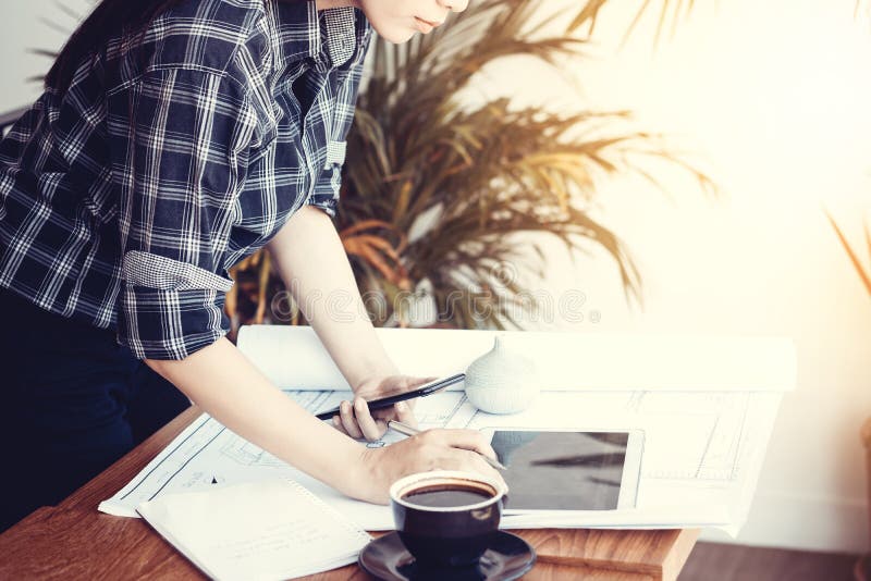 Mujer asiática del arquitecto que trabaja en casa con la tableta y los modelos imagenes de archivo