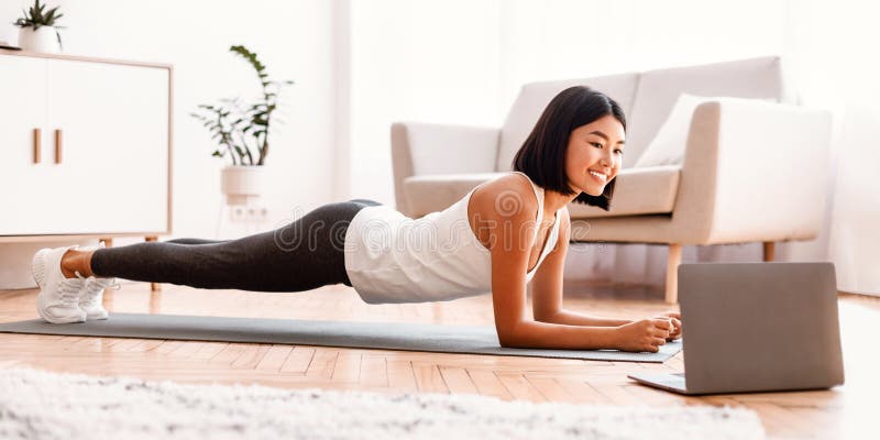 Mujer asiática deportiva haciendo tutorial de observación de planchas en laptop imagenes de archivo