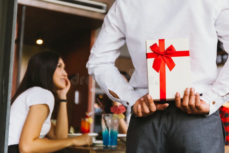 Asian women expected to receive a surprise present gift box from men as a romantic couple for occasional anniversary celebration. Asian women expected to receive a surprise present gift box from men as a romantic couple for occasional anniversary celebration