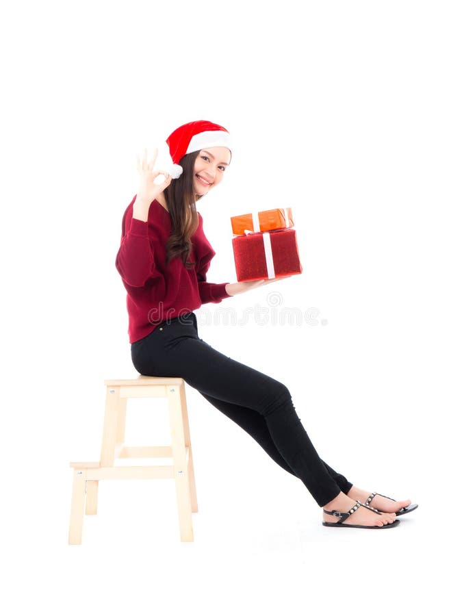 Mujer asiática feliz que sienta con la caja de regalo de la tenencia de la sonrisa muchas de Navidad, actual muchacha con la Navi imagen de archivo Mujer asiática feliz que sienta con la caja de regalo de la tenencia de la sonrisa muchas de Navidad, actual muchacha con la Navi imagen de archivo