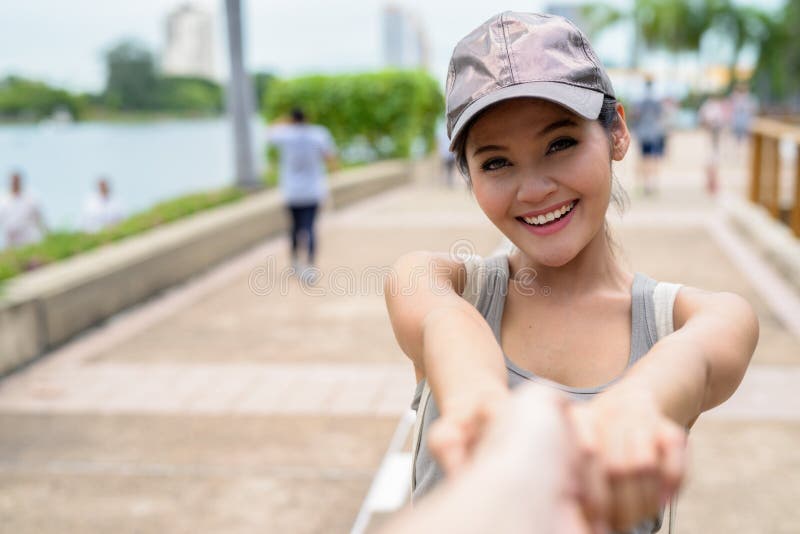 Mujer asiática hermosa joven que se relaja en el parque imagen de archivo Mujer asiática hermosa joven que se relaja en el parque imagen de archivo