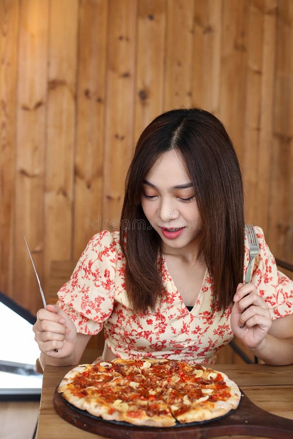 Mujer asiática joven hermosa que come la pizza deliciosa o deliciosa foto de archivo libre de regalías Mujer asiática joven hermosa que come la pizza deliciosa o deliciosa foto de archivo libre de regalías