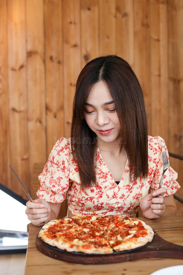 Mujer asiática joven hermosa que come la pizza deliciosa o deliciosa foto de archivo libre de regalías Mujer asiática joven hermosa que come la pizza deliciosa o deliciosa foto de archivo libre de regalías