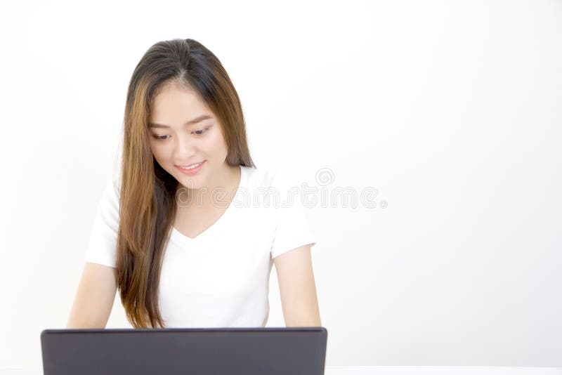 Mujer asiática joven hermosa que se sienta delante del ordenador portátil fotografía de archivo Mujer asiática joven hermosa que se sienta delante del ordenador portátil fotografía de archivo