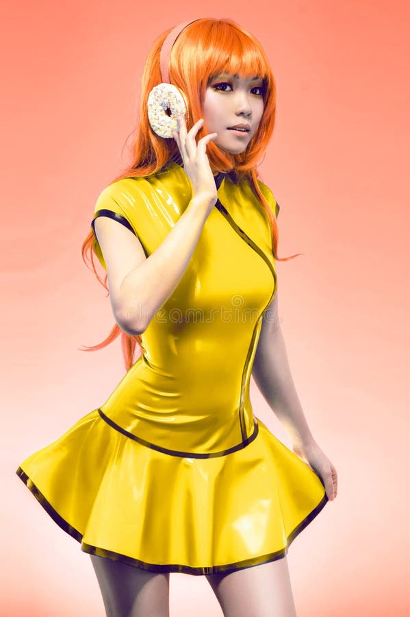 Young asian woman posing in yellow dress with donut headphones. Young asian woman posing in yellow dress with donut headphones