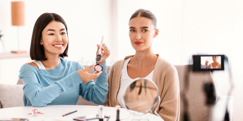 Mujer asiática maquillando a su modelo fotografía de archivo