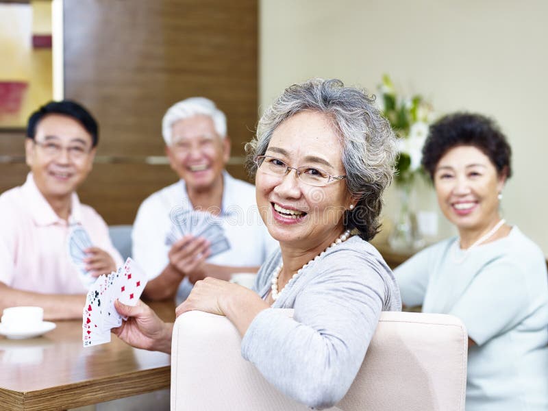 Mujer asiática mayor en juego de tarjeta