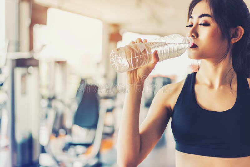 Mujer asiática que bebe el agua potable pura para la frescura después de wor foto de archivo libre de regalías Mujer asiática que bebe el agua potable pura para la frescura después de wor foto de archivo libre de regalías