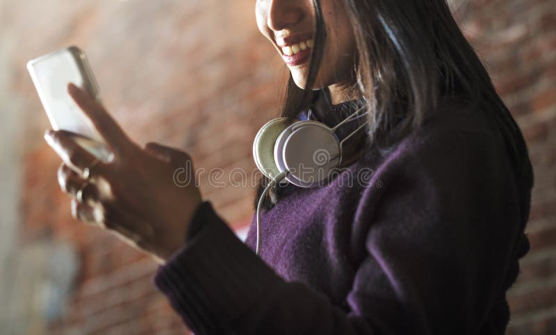 Mujer asiática que usa el dispositivo y los auriculares digitales foto de archivo Mujer asiática que usa el dispositivo y los auriculares digitales foto de archivo