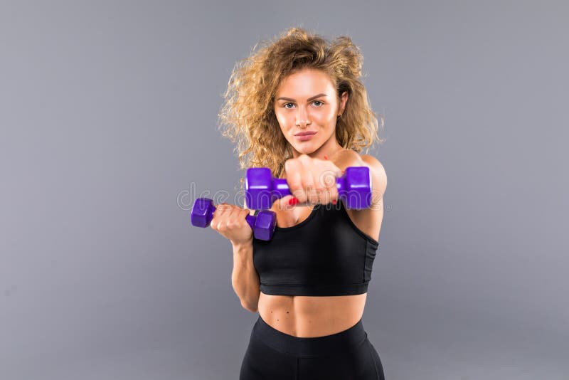 Mujer atlética que hace el ejercicio para los brazos Foto de la elaboración modelo de la aptitud muscular con pesas de gimnasia e fotos de archivo Mujer atlética que hace el ejercicio para los brazos Foto de la elaboración modelo de la aptitud muscular con pesas de gimnasia e fotos de archivo