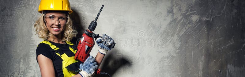 Mujer atractiva del constructor con una imagen horizontal del taladro foto de archivo libre de regalías