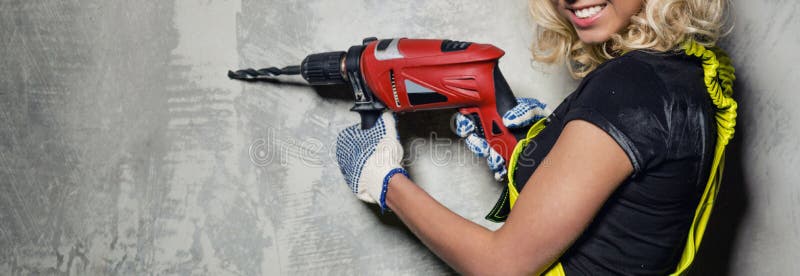 Mujer atractiva del constructor con una imagen horizontal del taladro foto de archivo