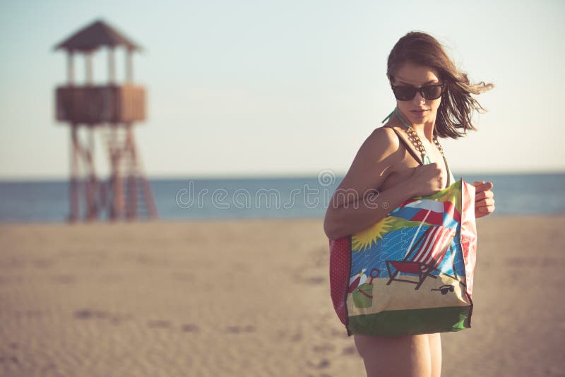 Mujer atractiva el vacaciones de la playa con los accesorios Accesorio de la playa El ir a las vacaciones de la playa arenosa Est