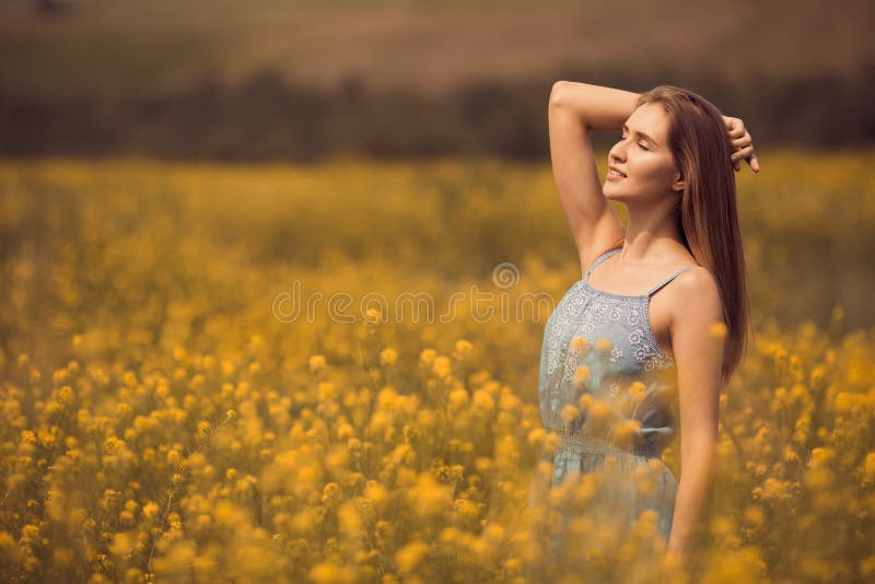 mujer atractiva en vestido en el campo de flor fotografía de archivo libre de regalías mujer atractiva en vestido en el campo de flor fotografía de archivo libre de regalías