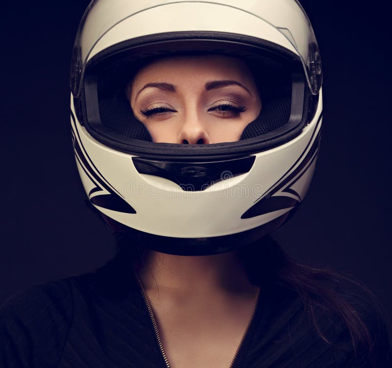 Mujer atractiva hermosa del maquillaje que mira en el casco blanco o de la motocicleta