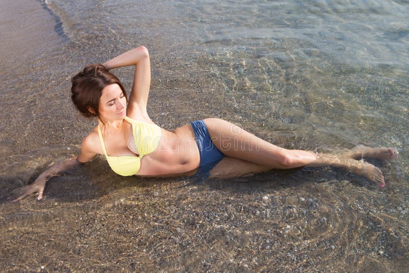 Mujer atractiva joven en un traje de baño en la agua de mar imágenes de archivo libres de regalías Mujer atractiva joven en un traje de baño en la agua de mar imágenes de archivo libres de regalías