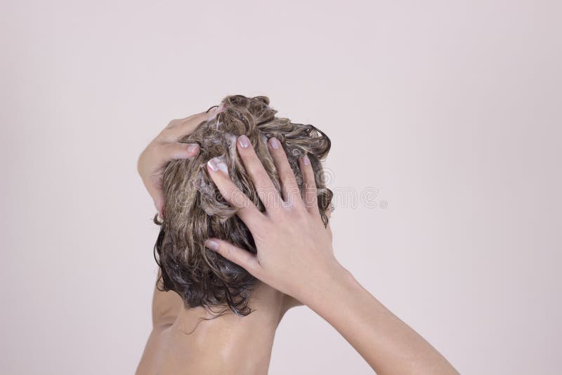 Mujer atractiva joven que se lava el pelo largo hermoso foto de archivo Mujer atractiva joven que se lava el pelo largo hermoso foto de archivo