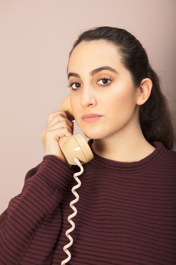 Mujer atractiva que escucha una conversación telefónica imagen de archivo Mujer atractiva que escucha una conversación telefónica imagen de archivo