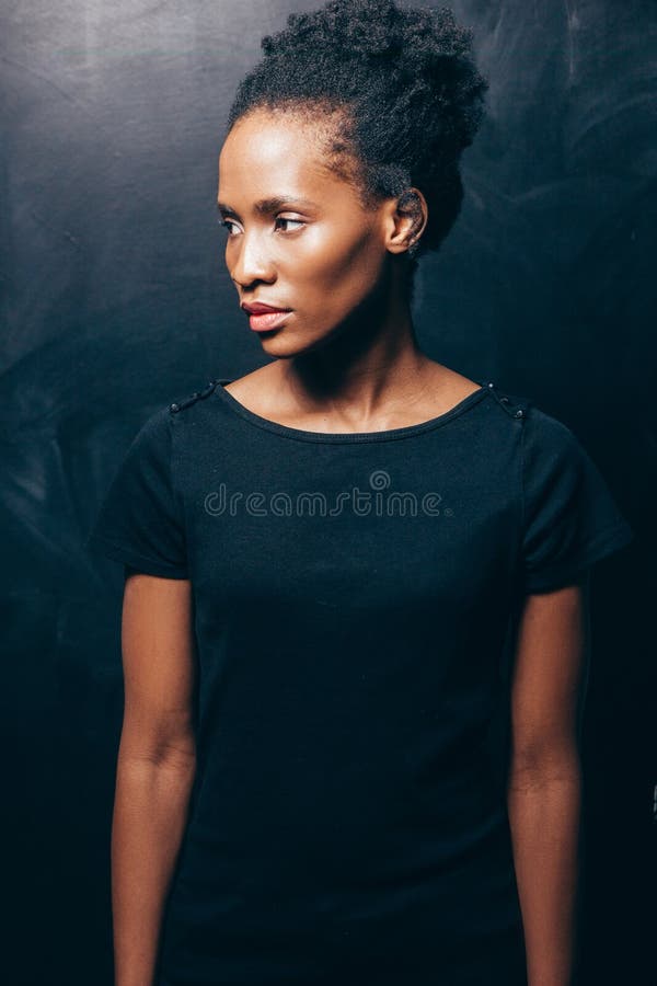 Mujer bastante afroamericana en fondo oscuro imagen de archivo libre de regalías Mujer bastante afroamericana en fondo oscuro imagen de archivo libre de regalías