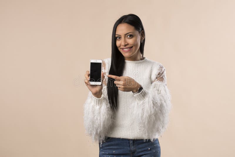 Mujer bastante joven de Latina que muestra la pantalla del teléfono foto de archivo libre de regalías Mujer bastante joven de Latina que muestra la pantalla del teléfono foto de archivo libre de regalías