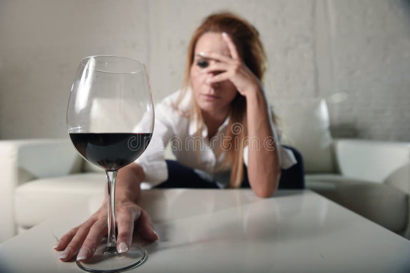 Mujer bebida alcohólico deprimido triste que bebe en casa en abuso de alcohol del ama de casa y alcoholismo foto de archivo libre de regalías Mujer bebida alcohólico deprimido triste que bebe en casa en abuso de alcohol del ama de casa y alcoholismo foto de archivo libre de regalías