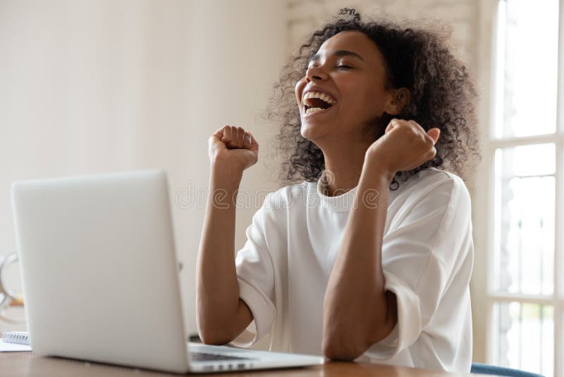Mujer biracial muy feliz se siente emocionada ganar lotería en laptop