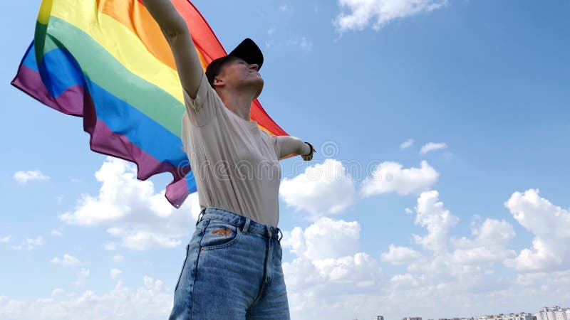 Mujer bisexual con bandera lgbt en el fondo del cielo