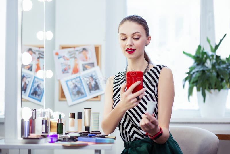 Mujer bonita agradable que toma una foto de su crema foto de archivo libre de regalías Mujer bonita agradable que toma una foto de su crema foto de archivo libre de regalías