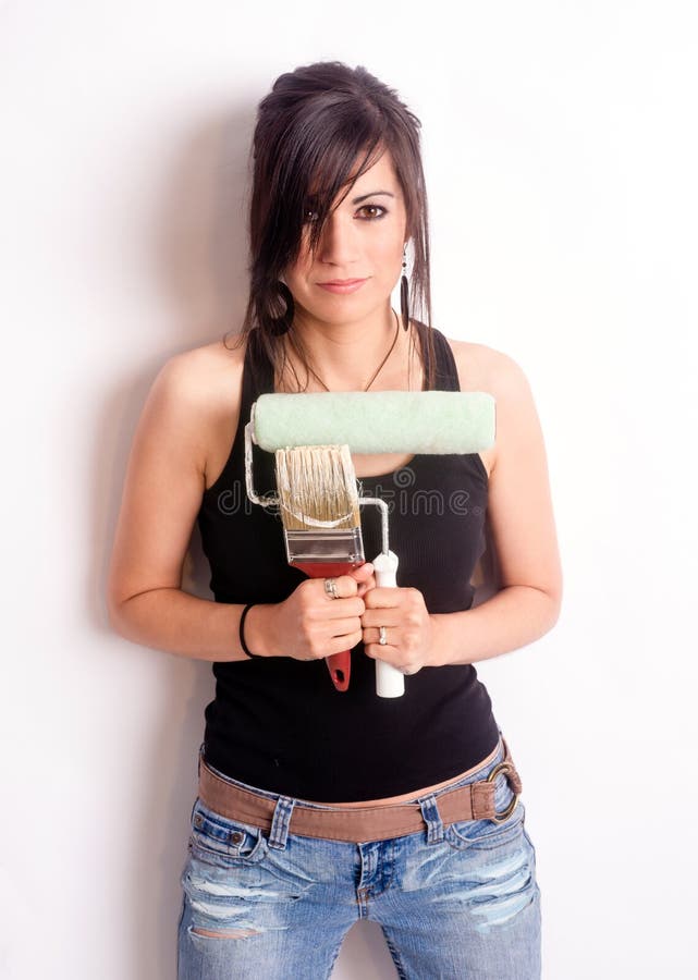 Mujer bonita de la cadera que sostiene el rodillo del cepillo de las herramientas de la pintura fotografía de archivo libre de regalías Mujer bonita de la cadera que sostiene el rodillo del cepillo de las herramientas de la pintura fotografía de archivo libre de regalías