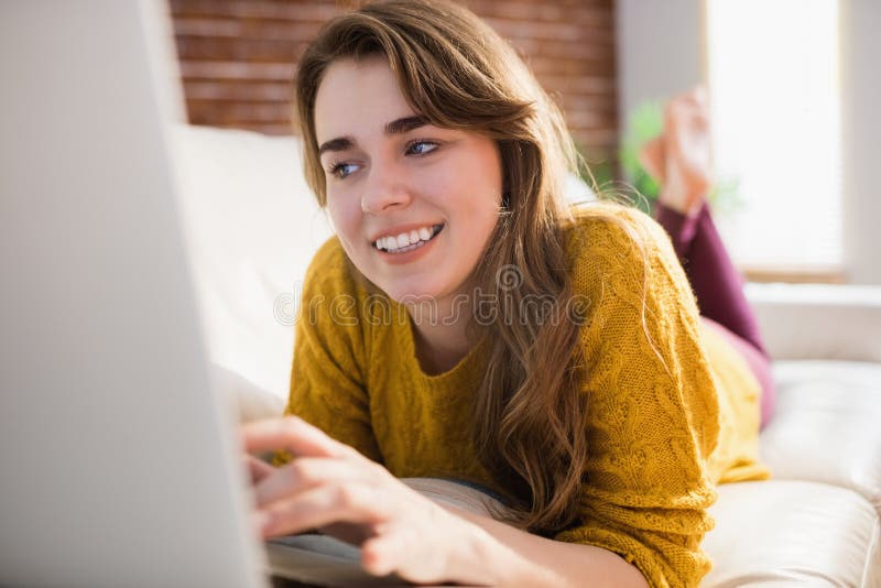 Mujer bonita sonriente que usa el ordenador portátil fotografía de archivo libre de regalías Mujer bonita sonriente que usa el ordenador portátil fotografía de archivo libre de regalías
