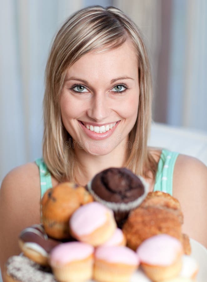 Bright woman holding a plate of cakes at home. Bright woman holding a plate of cakes at home