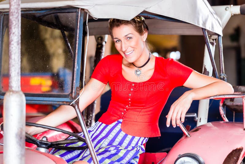 Mujer bávara con el vestido que conduce el tractor foto de archivo libre de regalías Mujer bávara con el vestido que conduce el tractor foto de archivo libre de regalías