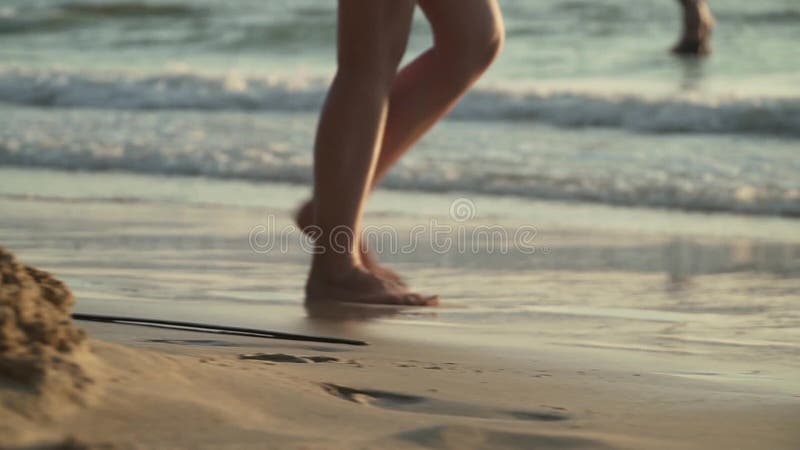 Mujer caminando en la playa al atardecer.