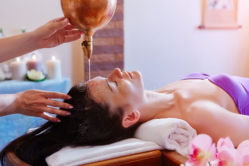 Mujer caucásica que tiene tratamiento del shirodhara de Ayurveda fotografía de archivo Mujer caucásica que tiene tratamiento del shirodhara de Ayurveda fotografía de archivo