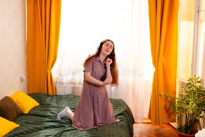 Mujer caucásica sonriente disfrutando un momento de relajación bailando y escuchando música. Imagen de pantalla ancha imagen de archivo libre de regalías