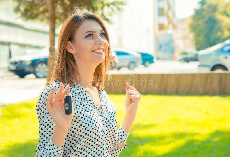 Mujer celebrando al conductor sosteniendo la llave de su auto nuevo, automóvil fotos de archivo libres de regalías Mujer celebrando al conductor sosteniendo la llave de su auto nuevo, automóvil fotos de archivo libres de regalías
