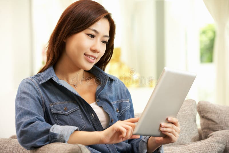 Mujer china joven que usa la tablilla de Digitaces imagen de archivo libre de regalías
