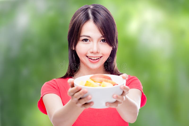 Mujer china que sostiene el cuenco de fruta imagen de archivo libre de regalías Mujer china que sostiene el cuenco de fruta imagen de archivo libre de regalías