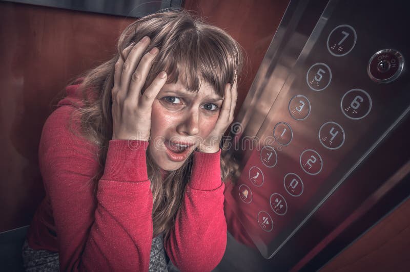 Mujer chocada con claustrofobia en el elevador m?vil foto de archivo libre de regalías Mujer chocada con claustrofobia en el elevador m?vil foto de archivo libre de regalías