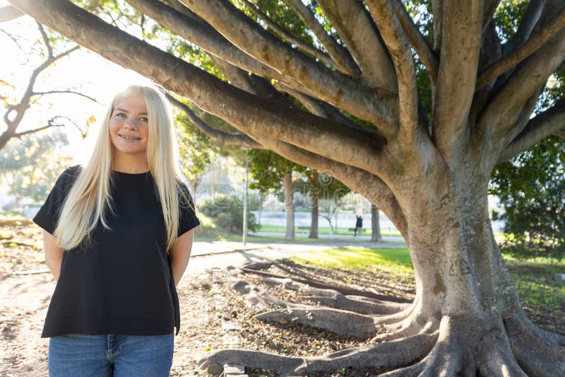 Mujer con bronce al lado de un gran árbol foto de archivo libre de regalías