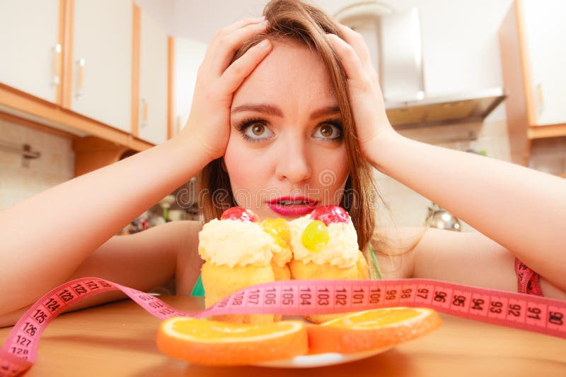 Mujer con cinta métrica y la torta Dilema de la dieta foto de archivo libre de regalías Mujer con cinta métrica y la torta Dilema de la dieta foto de archivo libre de regalías