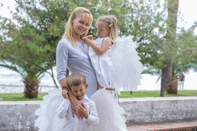 Mujer con dos niños camina por el parque fotografía de archivo libre de regalías
