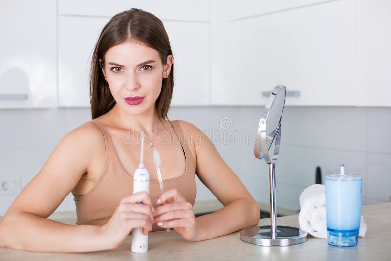 Mujer con el cepillo de dientes y el irrigator oral imagen de archivo Mujer con el cepillo de dientes y el irrigator oral imagen de archivo